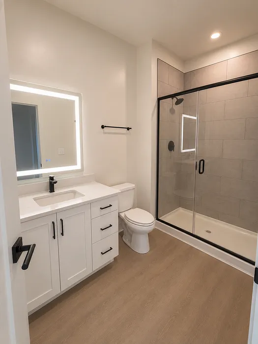 Elegant bathroom featuring modern fixtures, a sleek glass shower, and ample counter space, offering a stylish and functional design.
