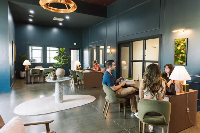 Modern and stylish office space with chic lighting, cozy seating, and vibrant decor for a welcoming atmosphere.