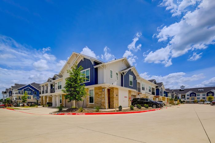 Exterior of Prosper Elms Apartments with attached garages in Prosper, TX