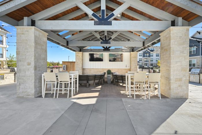 Outdoor covered patio area with grills on either side