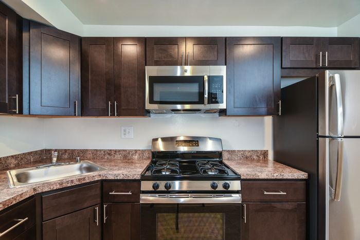 Stainless steel kitchen appliances. updated dark cabinets.