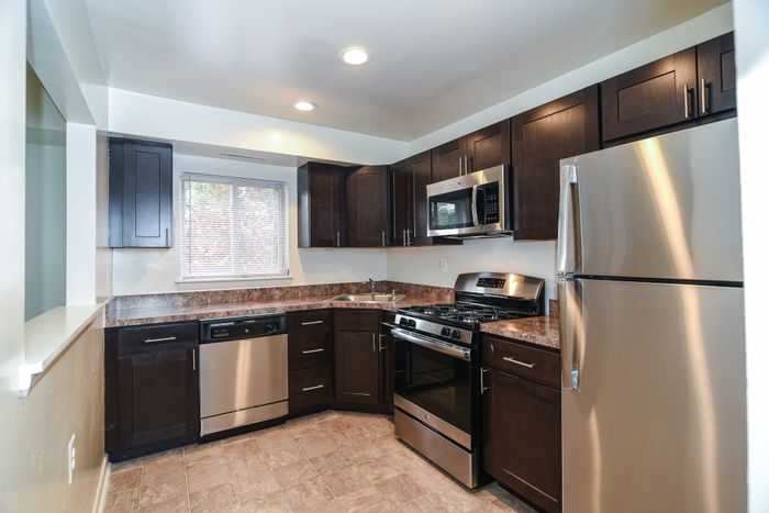 Stainless steel kitchen appliances. updated dark cabinets. wall cut out to living room