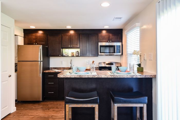Kitchen fully updated with stainless steel appliances (gas range, dishwasher, microwave, fridge), breakfast bar