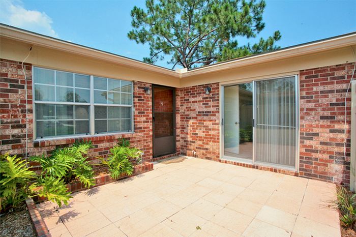 Beach Villas Apartments, exterior, brick building, patio, window, front door, sliding glass door, plants, tree