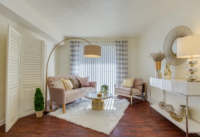 Canyon Square Apartments & Townhomes, interior, living room, wood floor, furry white area rug, pink sofa and chair, glass table, blinds on large window, lamps,