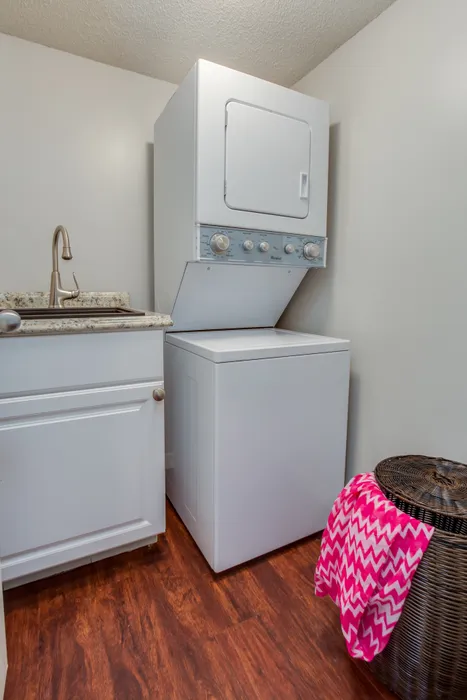 Canyon Square Apartments & Townhomes, interior, laundry room, wood floor, laundry basket, pink towel, stacked washer and dryer, sink, cabinet