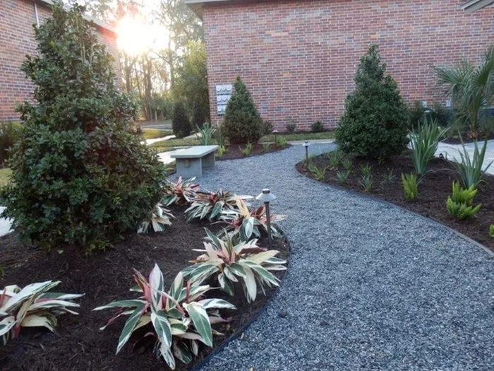 Canyon Square Apartments & Townhomes, gravel walk way, trees and plants, bench, brick building