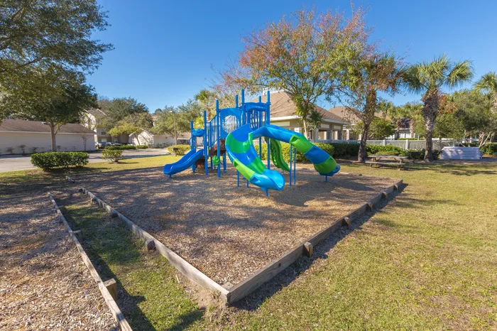 Creekside Park Apartments, exterior, play ground equipment, blue and green, trees, grass, buildings,