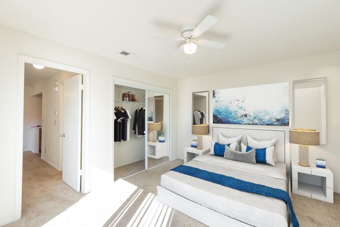 Beach Villas Apartments, interior, bedroom, blue and white decor, closet, carpet, bed, mirrors, wall art, ceiling fan, hallway