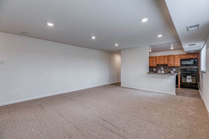 Living room, breakfast bar, and kitchen with updated black appliances