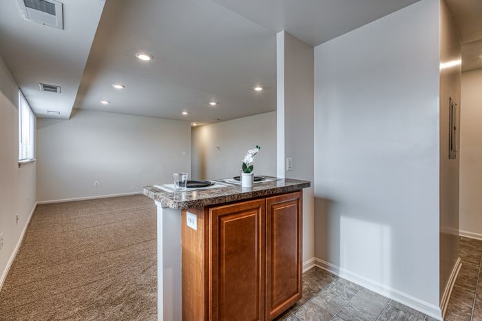 Breakfast bar and living room space with wall to wall carpet