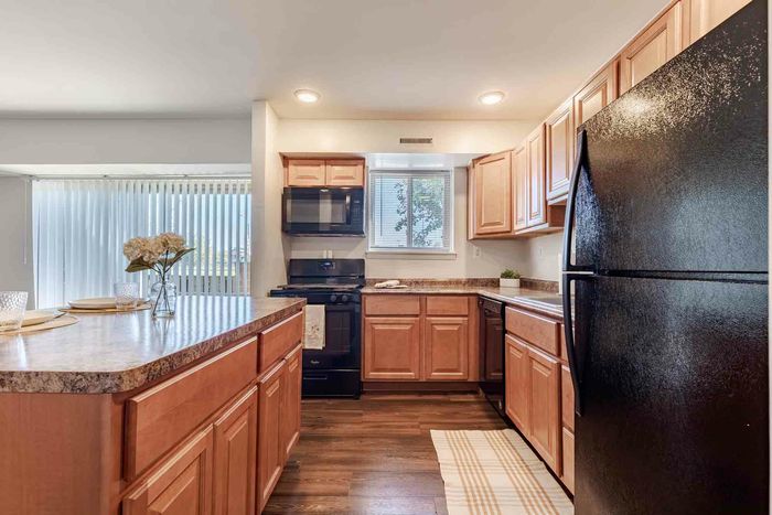 Open Kitchen with Island, Black Appliances and Plenty of Cabinetry