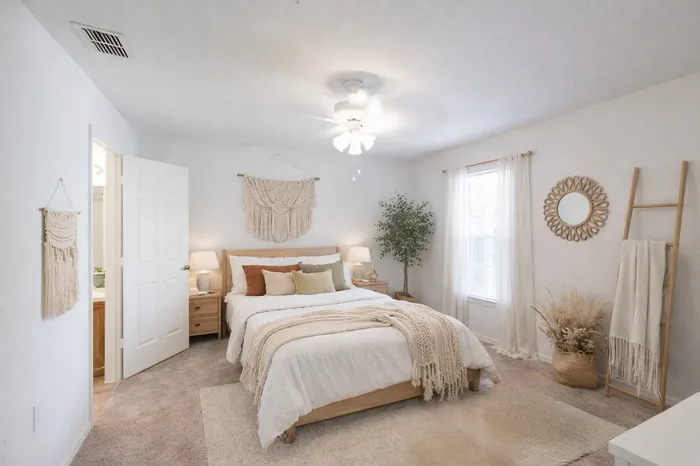 Bedroom with soft, natural tones. macrame wall art. en suite bath.