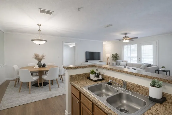 Open concept kitchen, dining, and living room spaces. Modern decor.