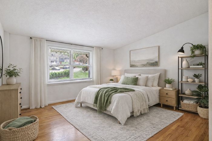 Bedroom with cathedral ceiling. green accents, plants, bed, nightstand, shelving unit.