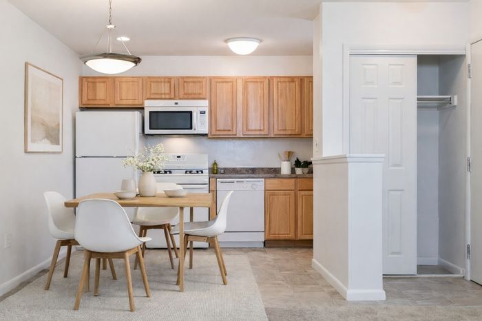 Kitchen dining space. table and 4 chairs. white appliances, maple cabinets.