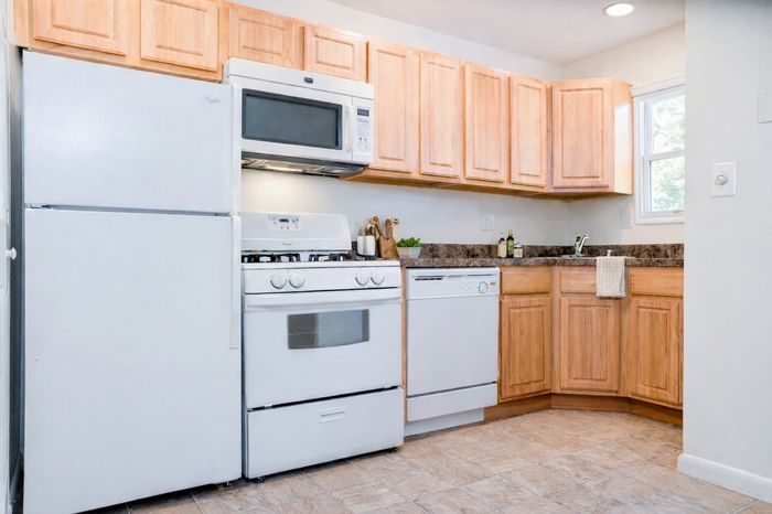Sunny kitchen. White appliances, maple cabinets.