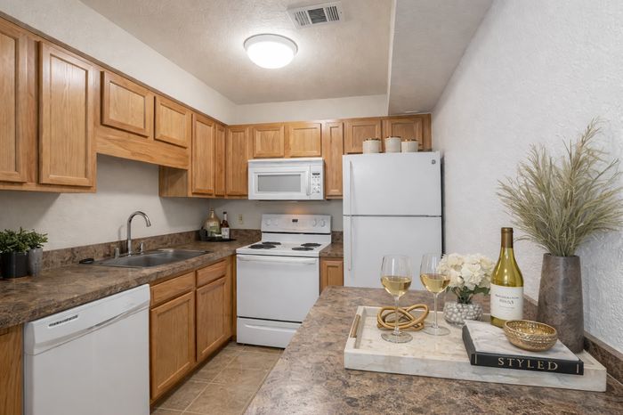 Beach Villas Apartments, interior, kitchen, wood floor, wood cabinets, white appliances, dishwasher, stove/oven, microwave, refrigerator,