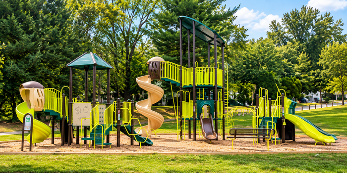Park Crescent Apartments outdoor playground with slides, climbing structures, and grassy surroundings