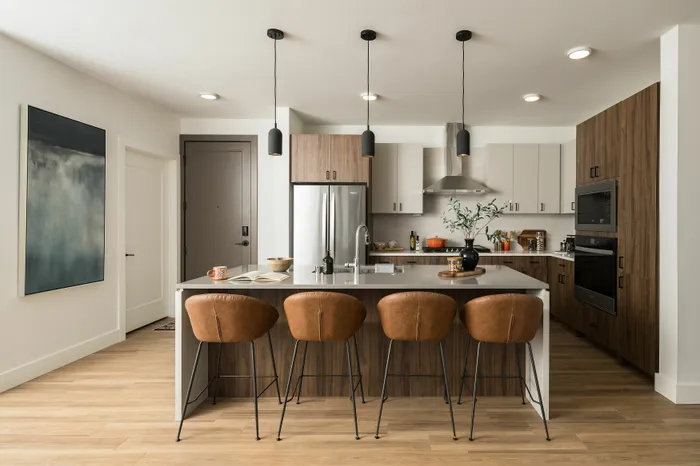 Contemporary kitchen with sleek island, modern appliances, and stylish bar stools.