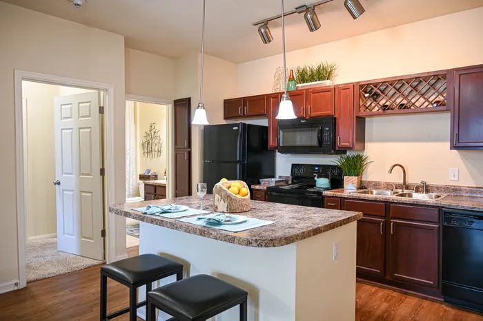 Chic kitchen with rich wood cabinetry, sleek appliances, and a stylish island, perfect for modern living.
