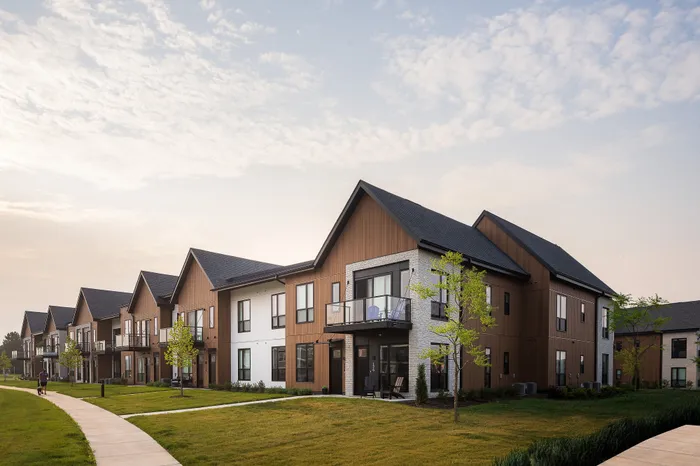 Charming modern apartment complex with wooden facades and private balconies, set in a lush green neighborhood with a serene walking path.