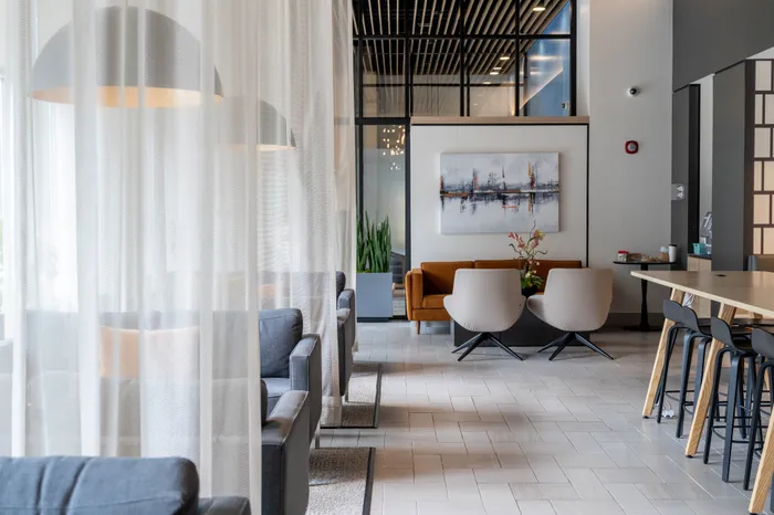Elegant and modern communal space with cozy seating, stylish pendant lights, and contemporary art on the wall.