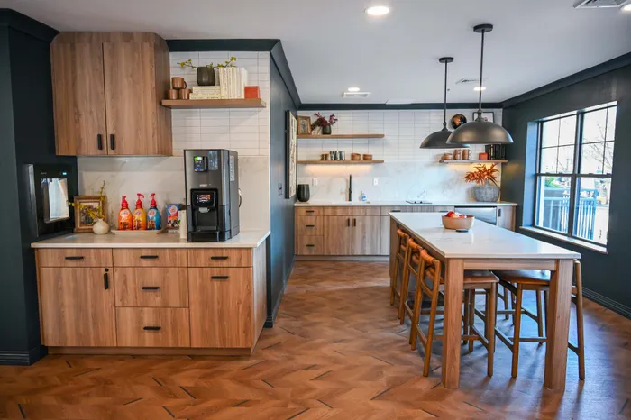 Beautiful modern kitchen with sleek wooden cabinets, elegant pendant lighting, and a spacious island with seating.