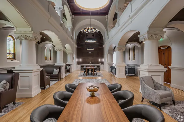 Elegant modern lounge with high ceilings, arched pillars, and chic seating, perfect for sophisticated gatherings.