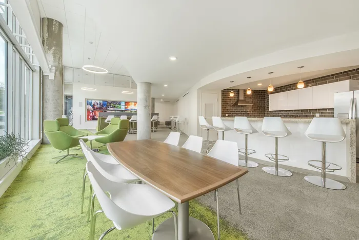 Modern open-concept lounge with elegant seating, stylish bar stools, and ambient lighting perfect for relaxation and entertainment.