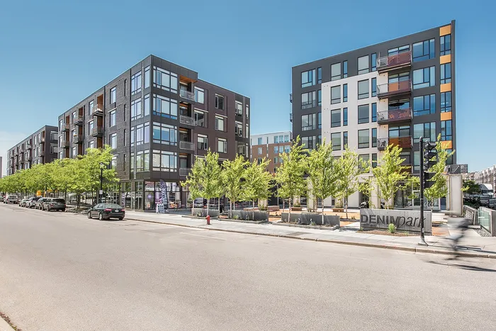 Contemporary urban apartment complex with modern architecture, large windows, and landscaped surroundings. Ideal city living with abundant natural light and sleek design.