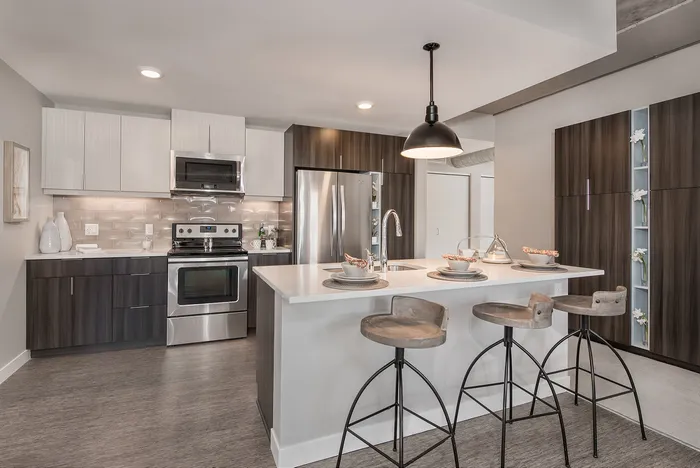 Modern kitchen with sleek stainless steel appliances, elegant island seating, and stylish cabinetry, perfect for entertaining.