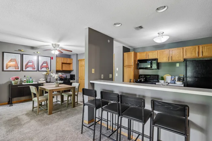 Inviting open-concept dining and kitchen area with modern appliances, cozy seating, and stylish decor.