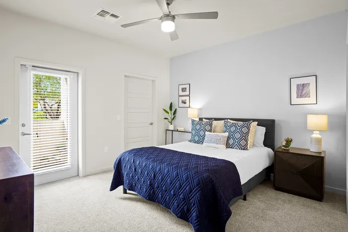 North Gateway, AZ Apartments - Acero North Valley - Spacious Bedroom With Plush Carpet, Ceiling Fan, And A Door Leading To Private Patio/ Deck.