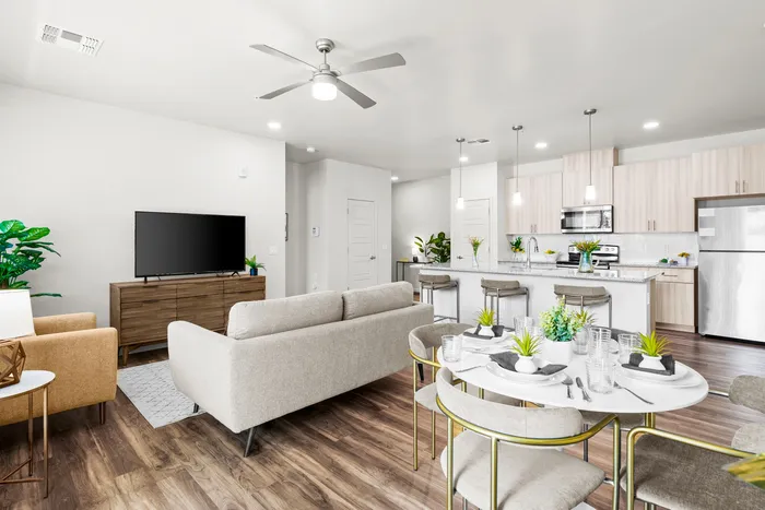 North Phoenix, AZ, Apartments Near Banner Health - Acero North Valley - A Living Room with a Sofa, TV, Wood-Style Flooring, and Contemporary Lighting.