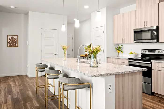 North Phoenix, AZ, Apartments Near Marketech International Corporation - Acero North Valley - A Kitchen Featuring a Large Island, Pendant Lighting, and Stainless Steel Appliances.