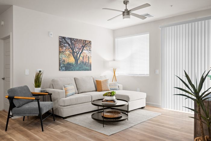 3-Bedroom Apartments in Queen Creek, AZ - Acero Harvest Station - Living Room with a Ceiling Fan, a Large Window, and Vinyl Plank Flooring