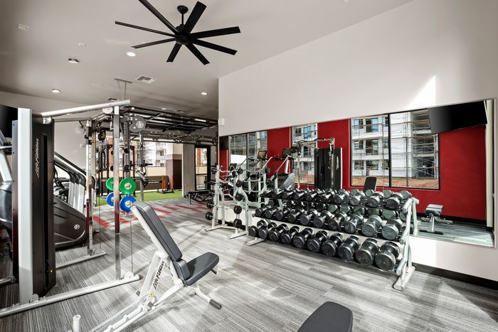East Mesa, AZ, Apartments - Acero Hawes Crossing - Fitness Center with Free Weights, Weight Lifting Bench, Cardio Machines, Ceiling Fan, Large Mirror, and Access to Outdoor Workout Area.
