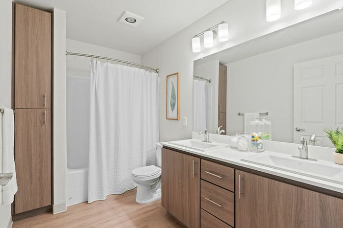 Vancouver WA Apartments Near Costco - Acero Jensen Park - Bathroom Featuring Large Mirror, Dual Sink, And Shower/Tub