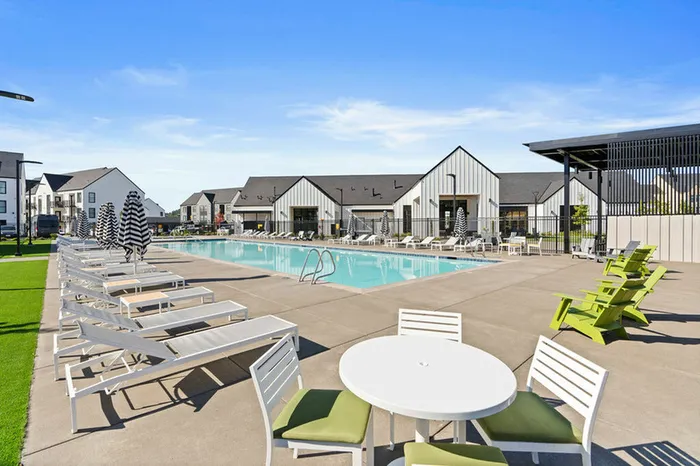 2 BR Apartments In Vancouver, WA - Bennington on First - Sparkling Swimming Pool With Lounge Chairs, Tables, Grass Area, And Umbrellas