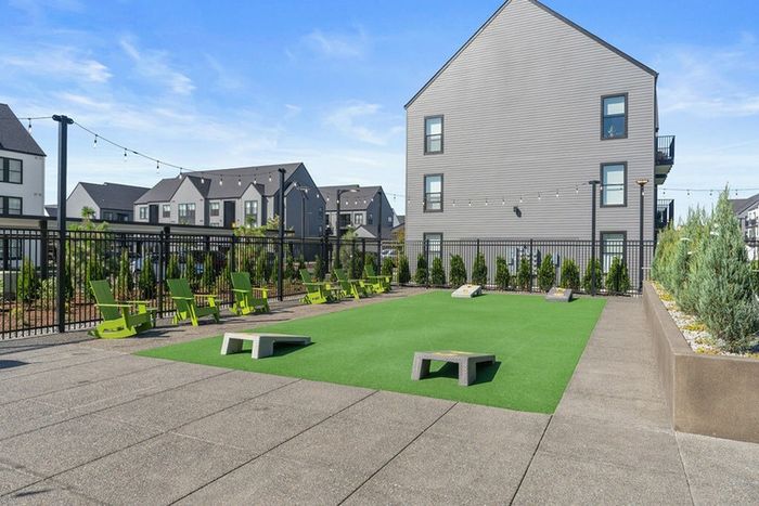 3 BR Apartments In Vancouver, WA - Bennington on First - Cornhole Game Area With Chairs And Outdoor Lights