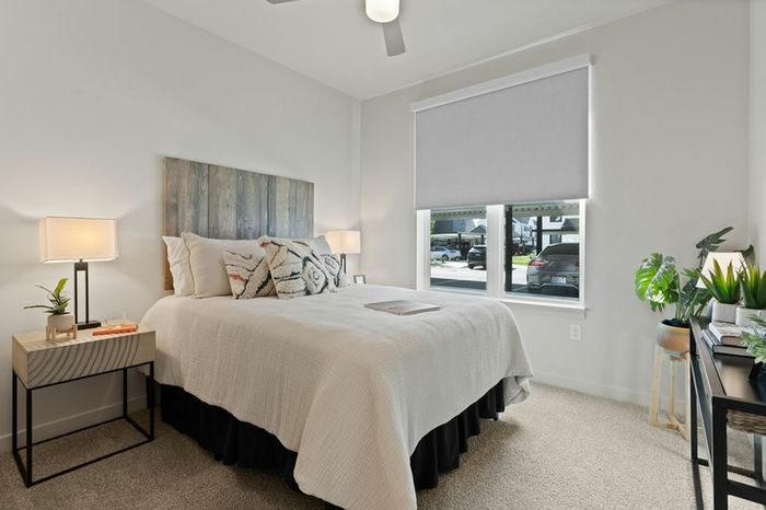 Apartments In Vancouver, WA - Bennington on First - Spacious Bedroom With A Ceiling Fan, Plush Carpet Flooring, and Connected Bathroom