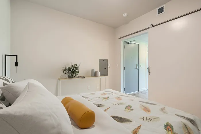 Bright and inviting bedroom with modern floral decor, featuring a cozy bed and elegant minimalist furnishings.