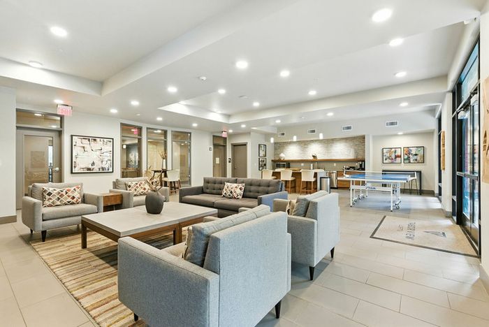 Modern apartment common area with elegant seating, vibrant decor, and recreational space featuring a ping pong table.