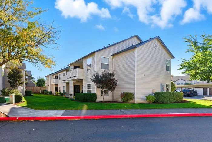Charming apartment building with beautifully manicured lawns and vibrant landscaping, offering a serene living environment.