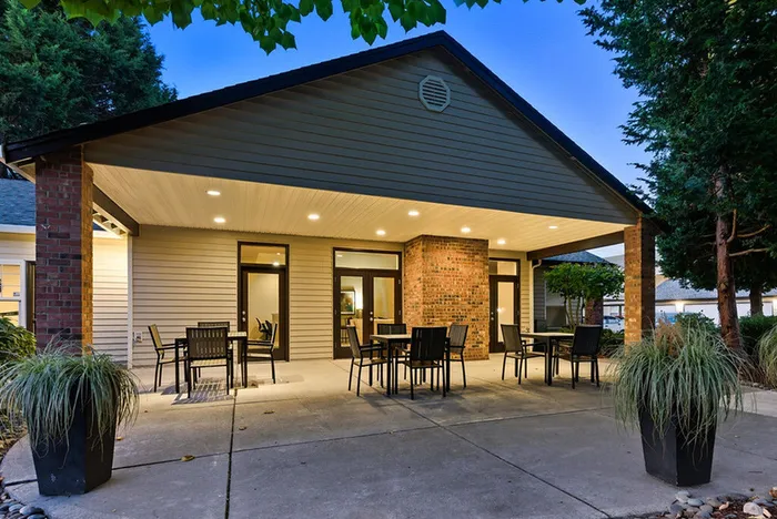 Inviting covered patio with modern seating, ambient lighting, and lush greenery, perfect for outdoor relaxation.