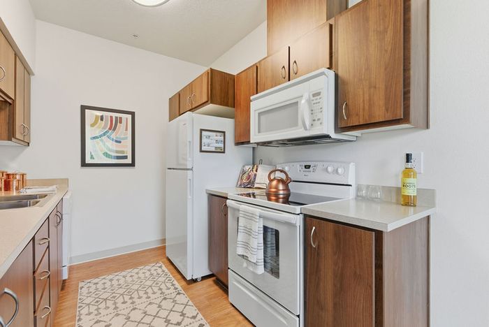 Chic modern kitchen showcasing elegant wood cabinets, pristine white appliances, and stylish countertop decor.