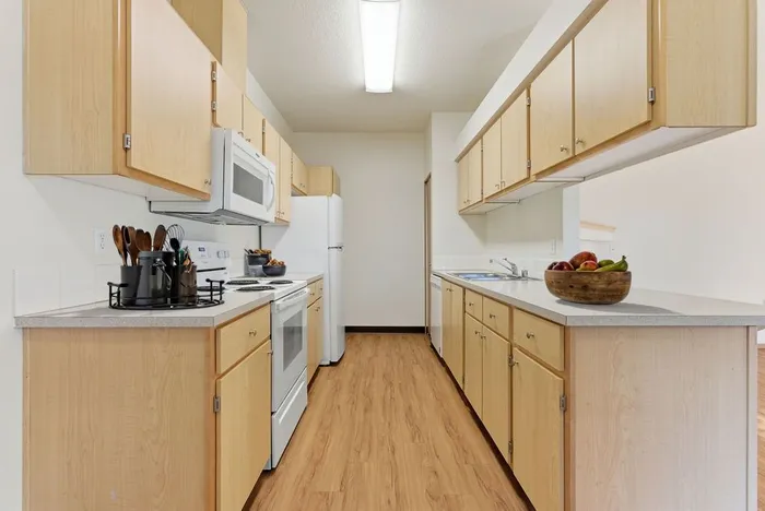 Bright modern kitchen with light wood cabinets, sleek countertops, and stylish appliances, ideal for culinary creativity.