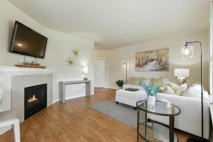 Inviting living room with cozy fireplace, elegant decor, and abundant natural light through large windows.