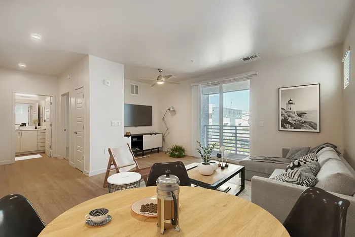 Bright, modern living space featuring a cozy sectional sofa, contemporary decor, and ample natural light from large windows.